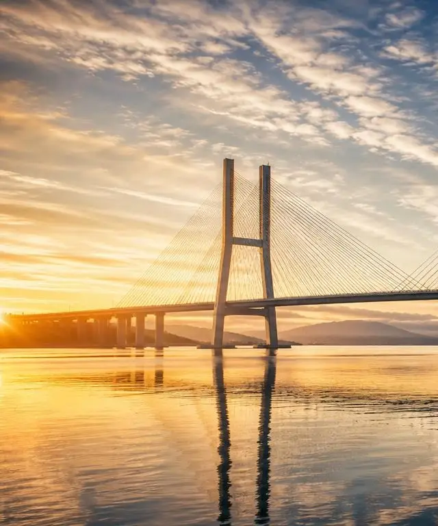 Left panel of a cable-stayed bridge reaching toward the sunrise horizon, symbolising vision